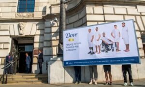 Ukraine Solidarity Project protesters hold a billboard – with a spoof of a Dove advertisement – outside the Unilever HQ in London. Photograph: Jill Mead/The Guardian