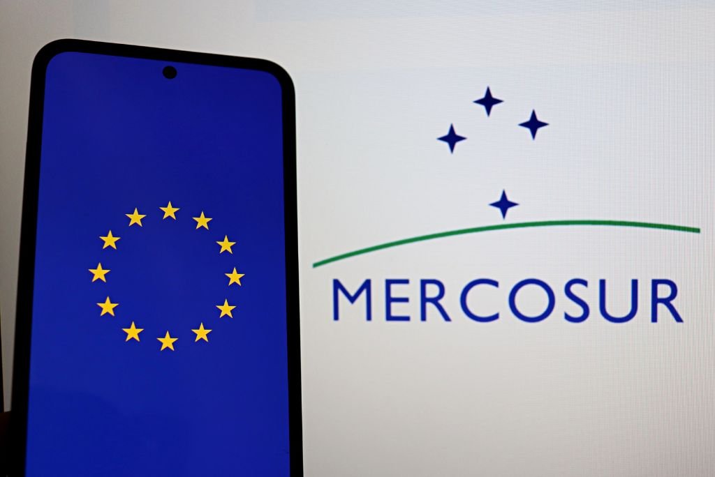 Smartphone displaying the European Union flag next to the Mercosur logo, symbolizing international trade relations between Europe and South America.