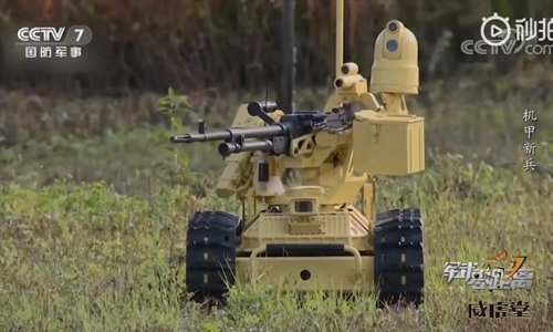 Remote-controlled robotic vehicle equipped with a machine gun in a grassy field, showcasing military technology and innovation.