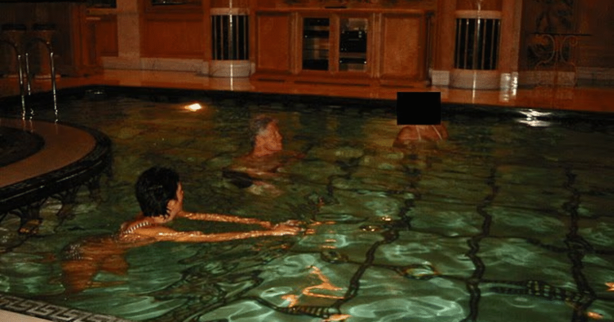 People swimming in a luxurious indoor pool surrounded by elegant wooden decor and soft lighting.