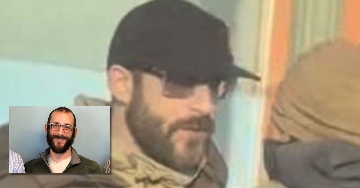 Man wearing a black cap and sunglasses, with a beard, engaged in conversation in a colorful setting.