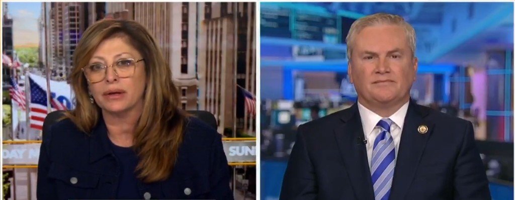 News segment featuring two political commentators discussing current events, with a backdrop of American flags and a modern newsroom setting.