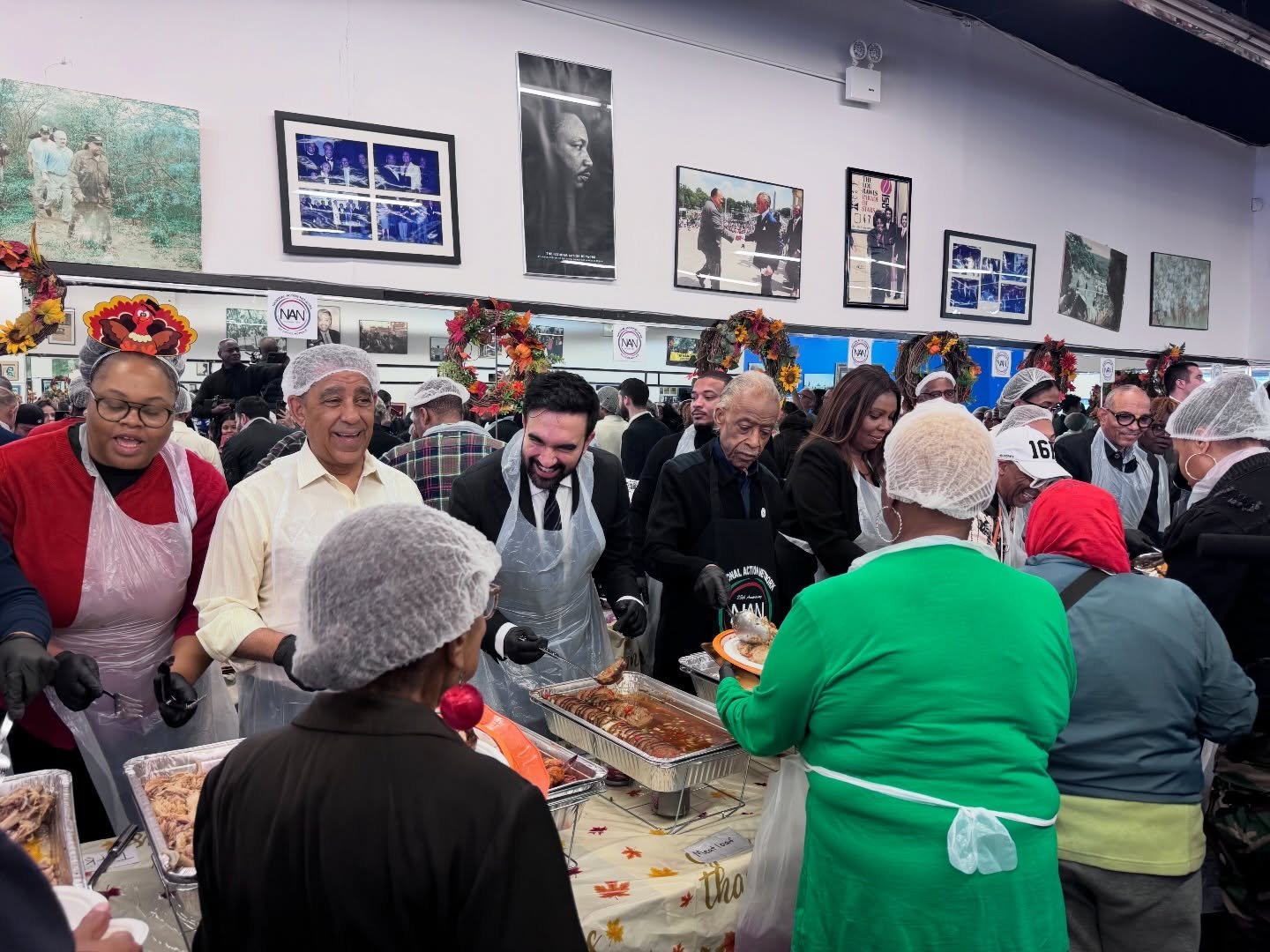 Volunteers serve meals at a community event, showcasing a diverse group of people engaged in food distribution and celebration.