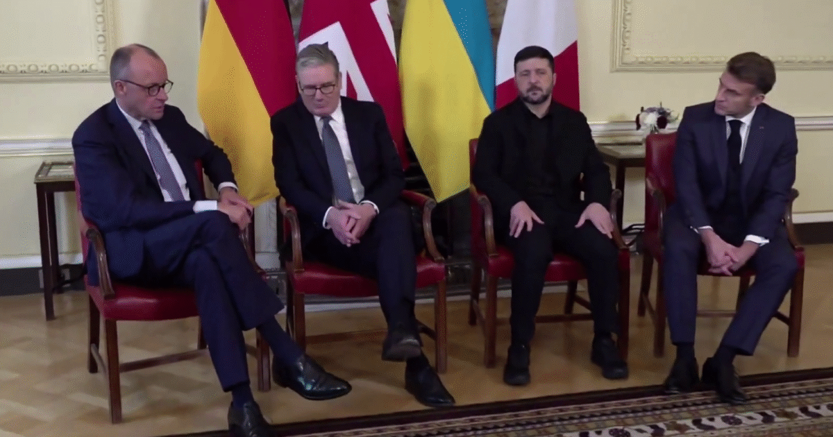 Leaders from Germany, the UK, Ukraine, and France seated together during a diplomatic meeting, with national flags displayed in the background.