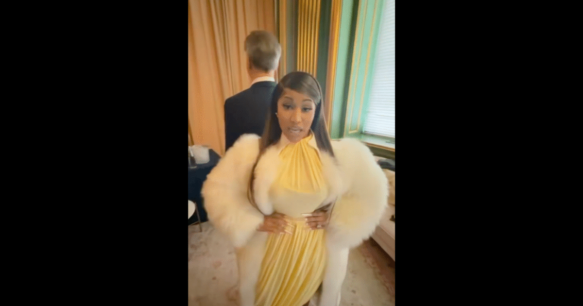 A woman in a stylish yellow dress with a fur coat stands confidently in a beautifully decorated room.