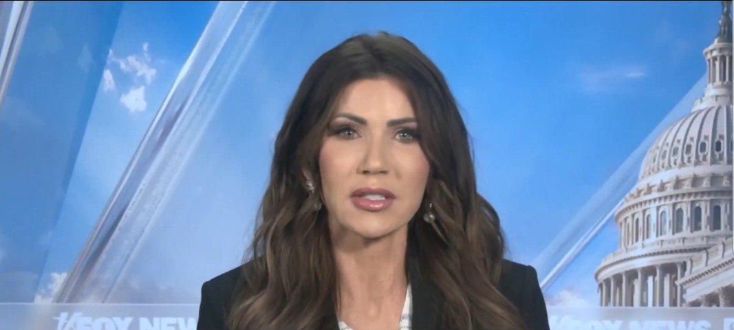 News anchor delivering a segment on Fox News with the U.S. Capitol in the background, featuring a clear blue sky.
