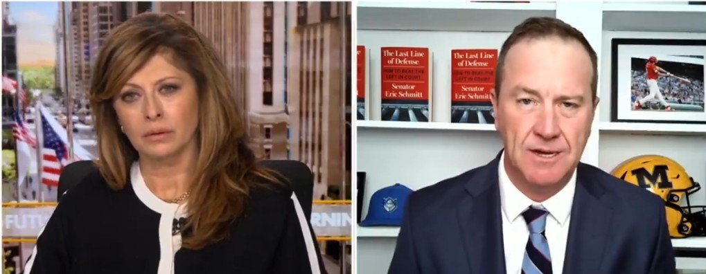 News interview featuring Maria Bartiromo and Senator Eric Schmitt discussing current political issues, with books and memorabilia in the background.