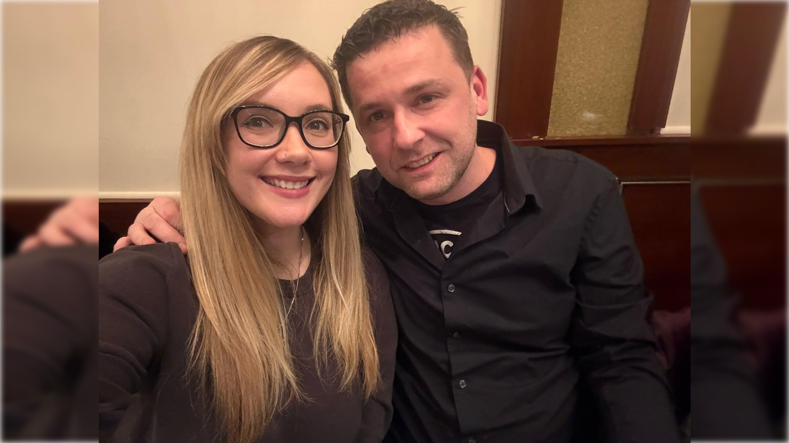 Smiling couple poses for a selfie in a cozy restaurant setting, showcasing a warm and friendly atmosphere.